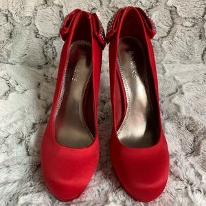 Red pump heels with jeweled bows on the back.